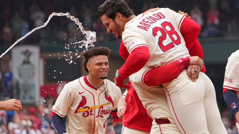 St. Louis Cardinals' Nolan Arenado (28) is congratulated by teammates after hitting a walk-off...