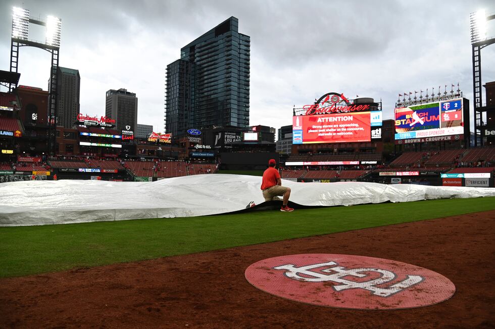 Busch Stadium grounds crew prepares the field prior to severe weather during the fifth inning...