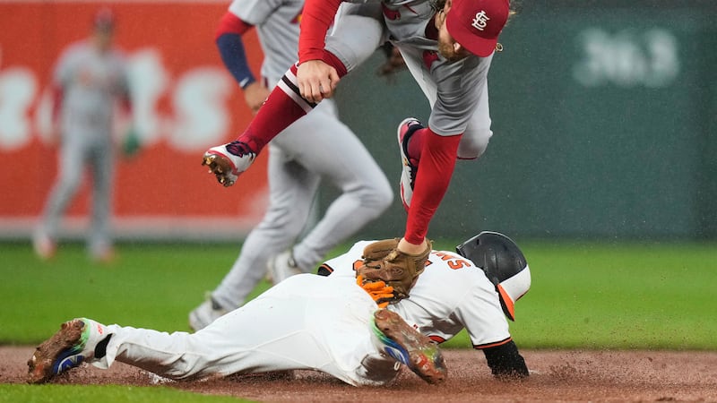 Baltimore Orioles' Cedric Mullins, below, steals second base in front of St. Louis Cardinals...