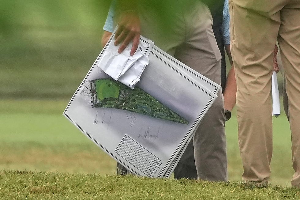 A person carries blueprints as President Donald Trump tours the East Potomac Park golf course,...