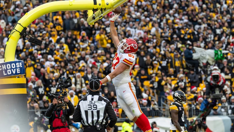 Kansas City Chiefs tight end Travis Kelce (87) dunks the football over the goal post after...