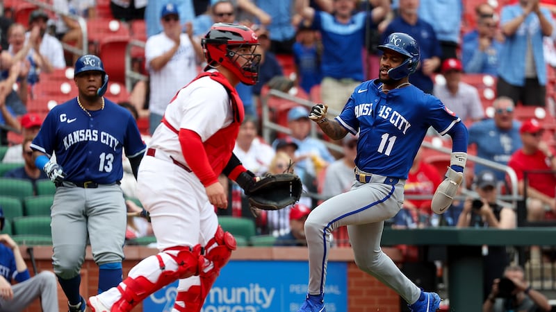 Kansas City Royals' Maikel Garcia (11) scores a run ahead of the throw to St. Louis Cardinals...